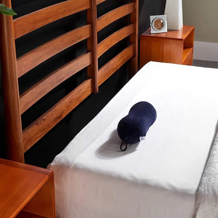 Navy TEMPUR All-Purpose Pillow shown on a bed.