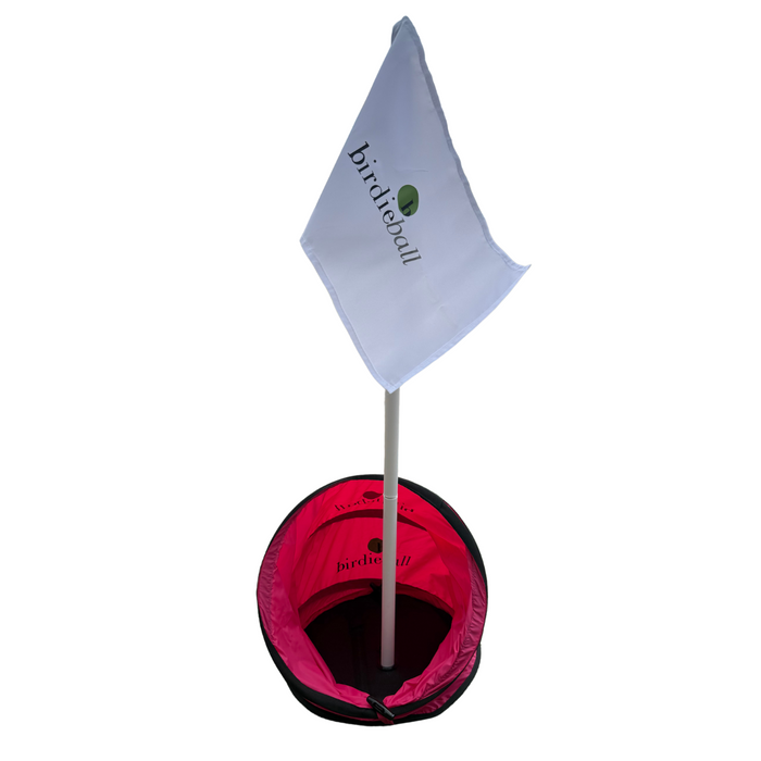 A white flag labeled "BirdieBall" is attached to a pole inserted in a BirdieTarget, the portable golf target by BirdieBall designed for chipping practice.