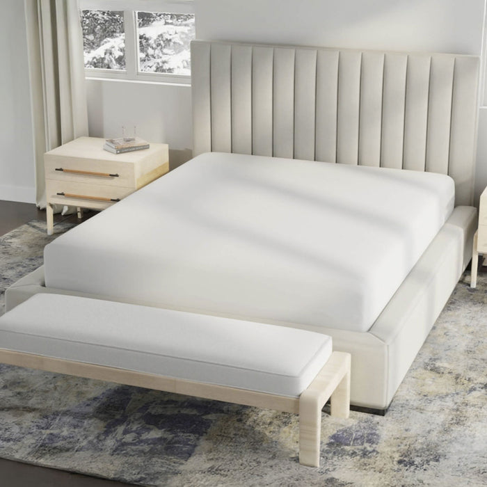 Beige upholstered bed with white mattress in a bedroom setting