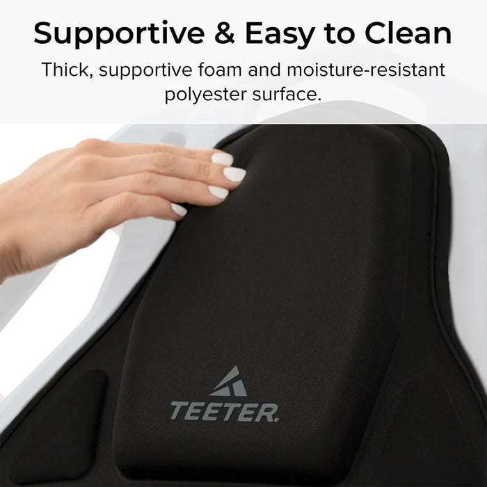 Close-up of the FitSpine Heat and Vibration Comfort Cushion by Teeter, featuring a black inversion table cushion. The text highlights its "Supportive and Easy to Clean" design, showcasing thick foam for comfort and a moisture-resistant polyester surface.