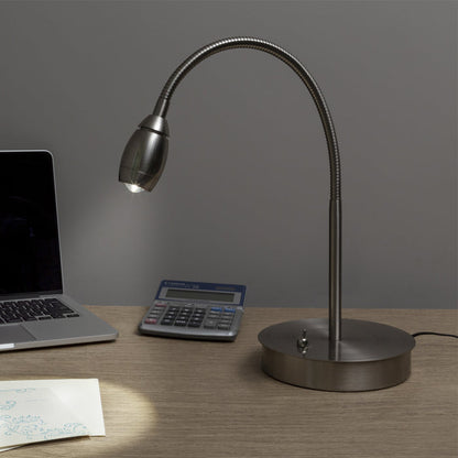 Flexi-neck desk lamp on a wooden surface with a laptop and calculator.