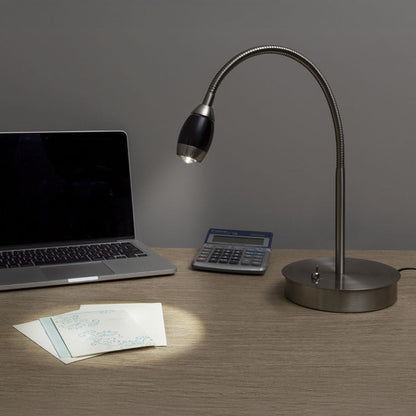 Desk setup with a laptop, calculator, and adjustable desk lamp on a wooden surface.