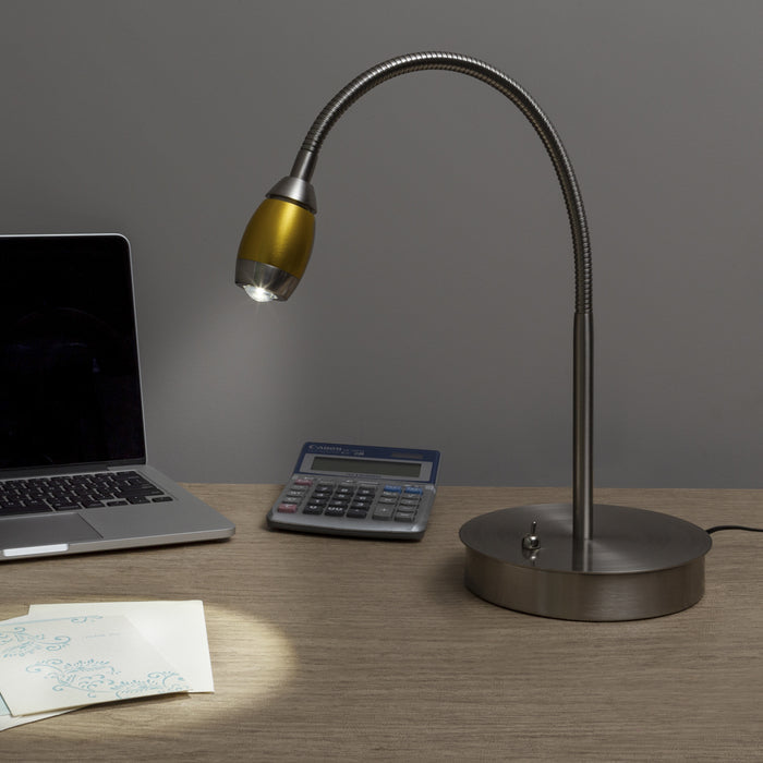 Desk setup with a lamp, laptop, and calculator on a wooden surface.