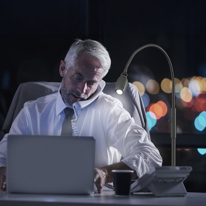 Man using the FOCUS Adjustable Beam Floor Lamp