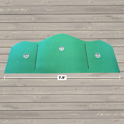 The BirdieBall Full Width Hole Deepening/Break Shim (For Use with Turf Mats) is a green, curved panel featuring Tour Grade Turf, three round vents, and two vertical slits, measuring 7.5 feet wide on a wooden floor background.