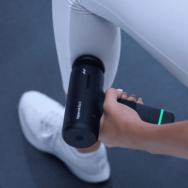 Person using a Hyperice Go3 massage device on their leg.