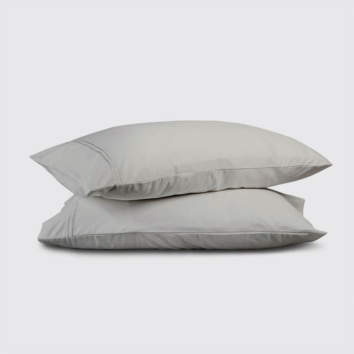 Two light gray pillows stacked on a white background