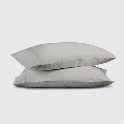 Two light gray pillows stacked on a white background