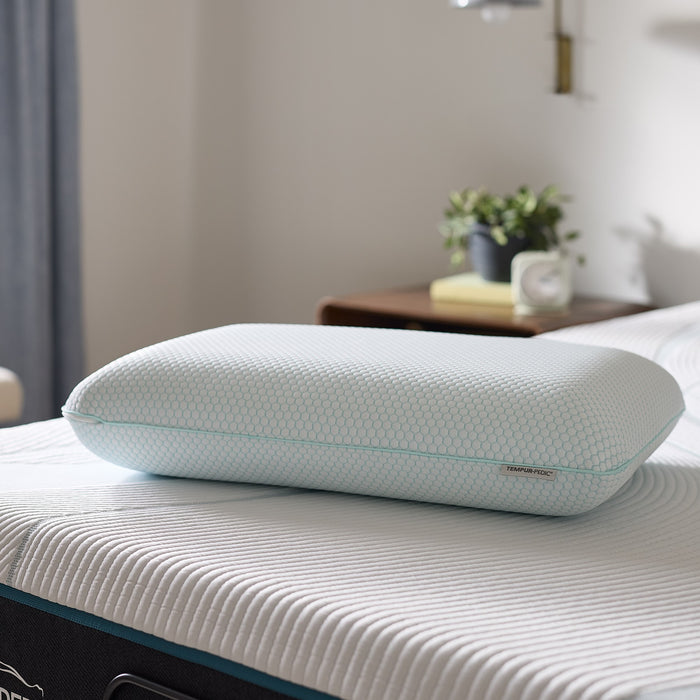 Ergonomic pillow on a bed with a blurred bedroom background