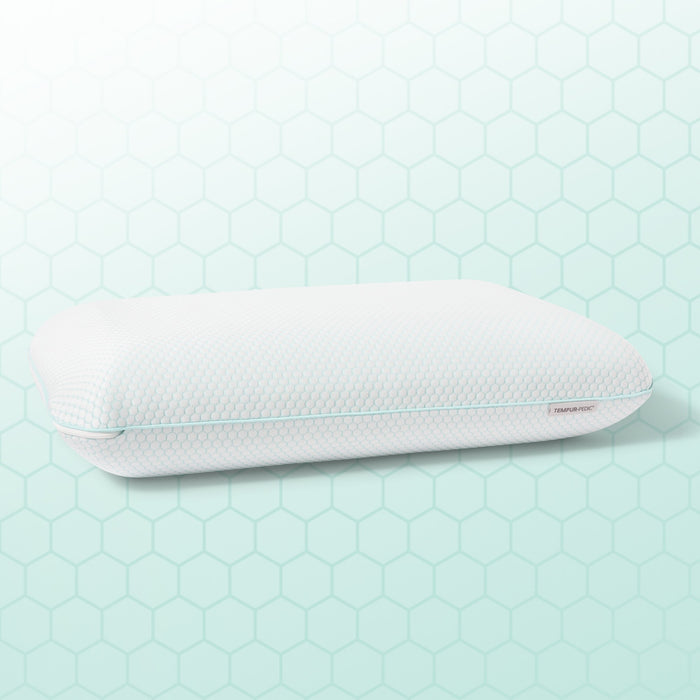 White pillow with a textured surface on a light green hexagonal patterned background