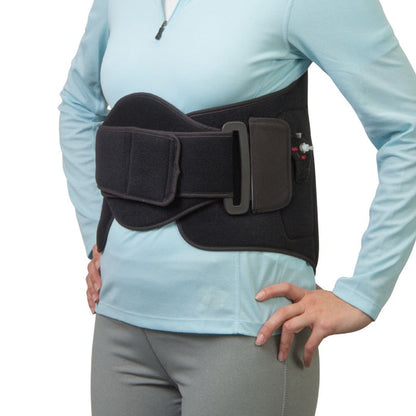 A black waist support belt worn by a model in a light blue long-sleeve top and gray pants, shown against a plain white background.