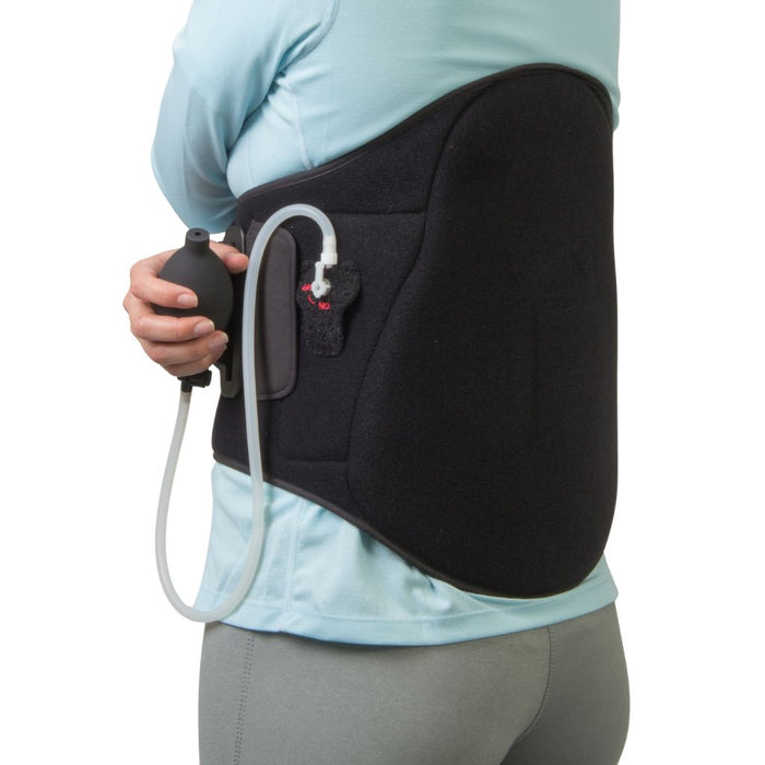 A person wearing a black high back support brace with an attached clear tube and black pump bulb, shown from the back against a white background.