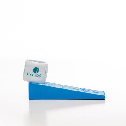 A white BirdieBall Velocity Tee for use with driver/woods sits on a blue plastic ramp, resembling a golf practice setup with tees, against a plain white background.