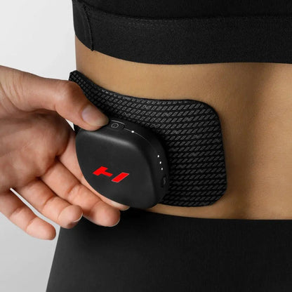 A woman using the Venom Go Portable Heat and Vibration Patch on her back.