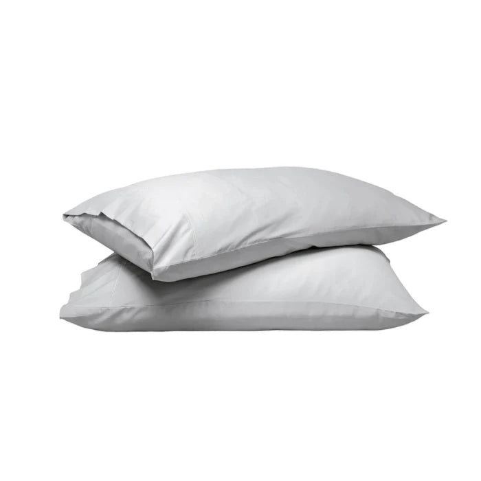 Two plain white pillows stacked on top of each other against a solid white background.