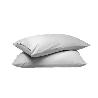 Two plain white pillows stacked on top of each other against a solid white background.