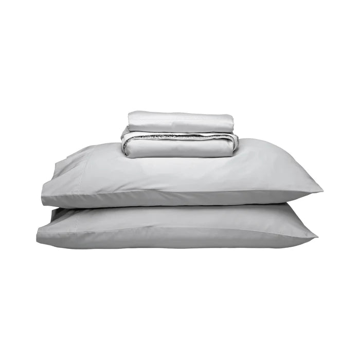 A stack of light gray bedding, including two pillows and a folded matching sheet, photographed on a plain white background.